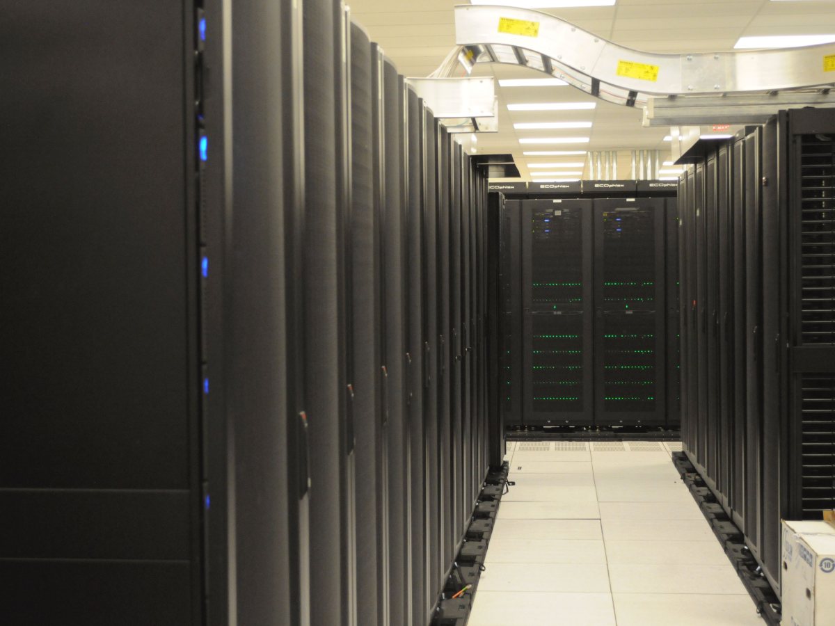 An aisle between rows of server racks in a data centre