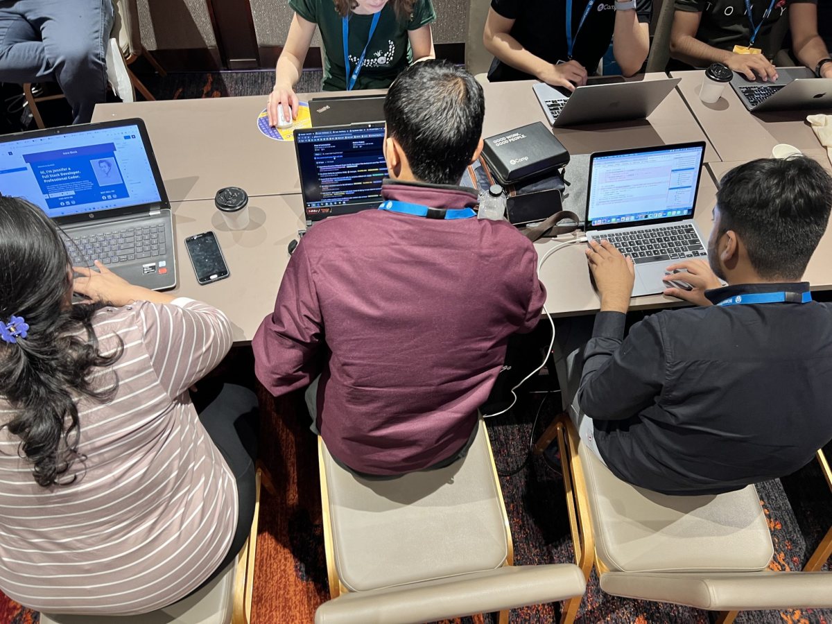 People sitting around a table working on laptops, seen from above People sitting around a table working on laptops, seen from above