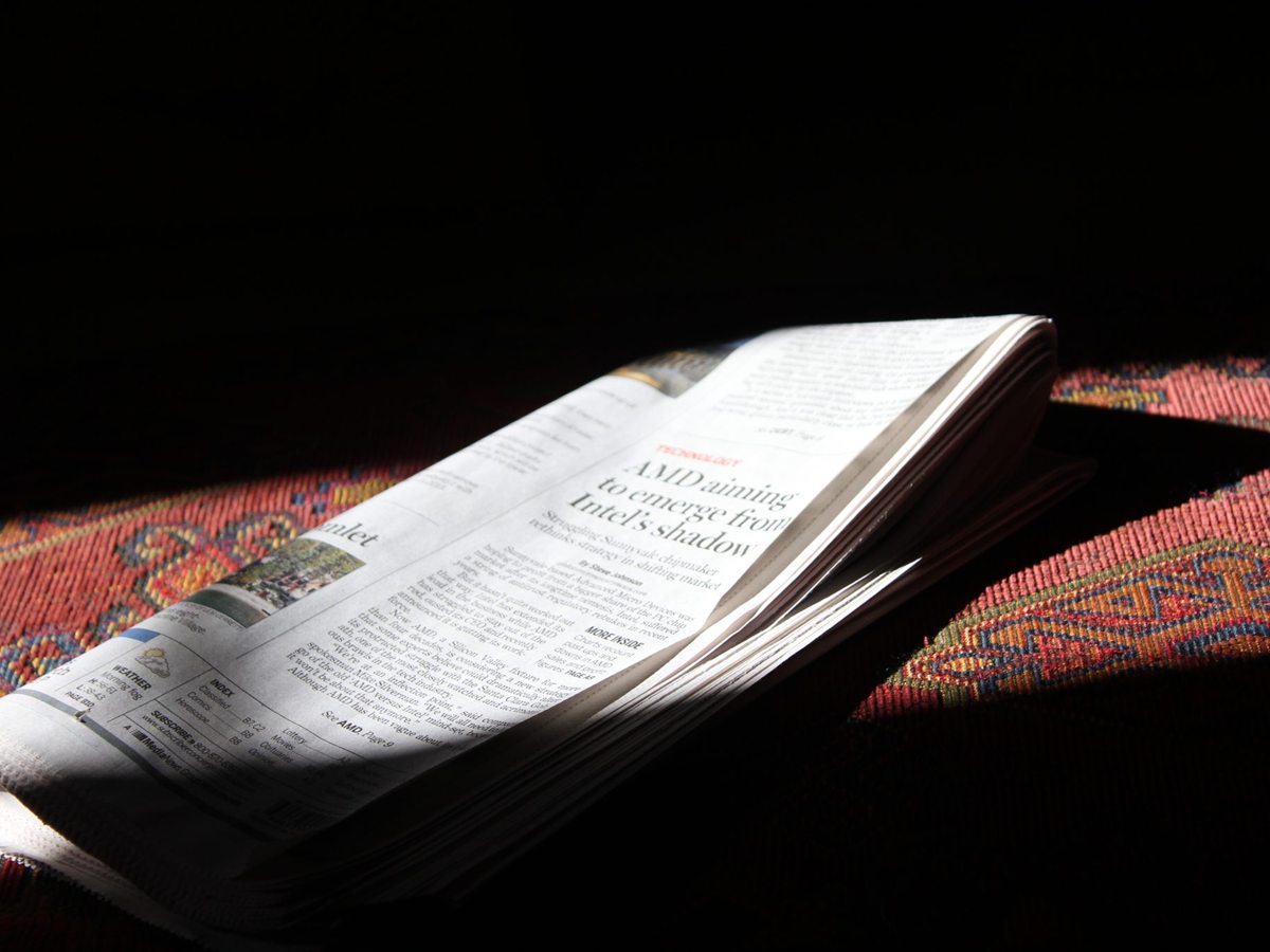 An open newspaper lying in a patch of sunlight. Otvorene novine na suncu.